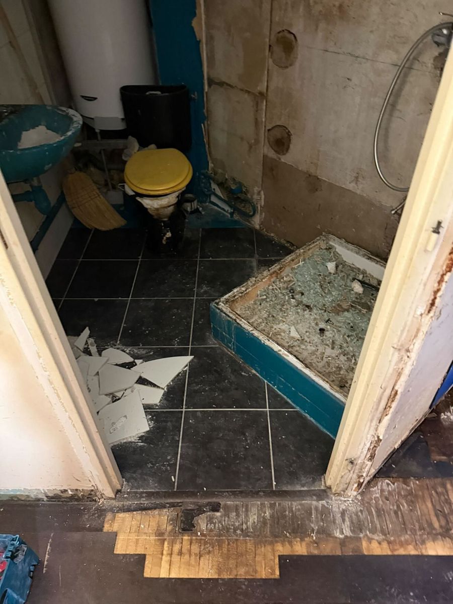 Sol carrelé cassé et receveur de douche endommagé avant rénovation d'une salle de bain au Vésinet