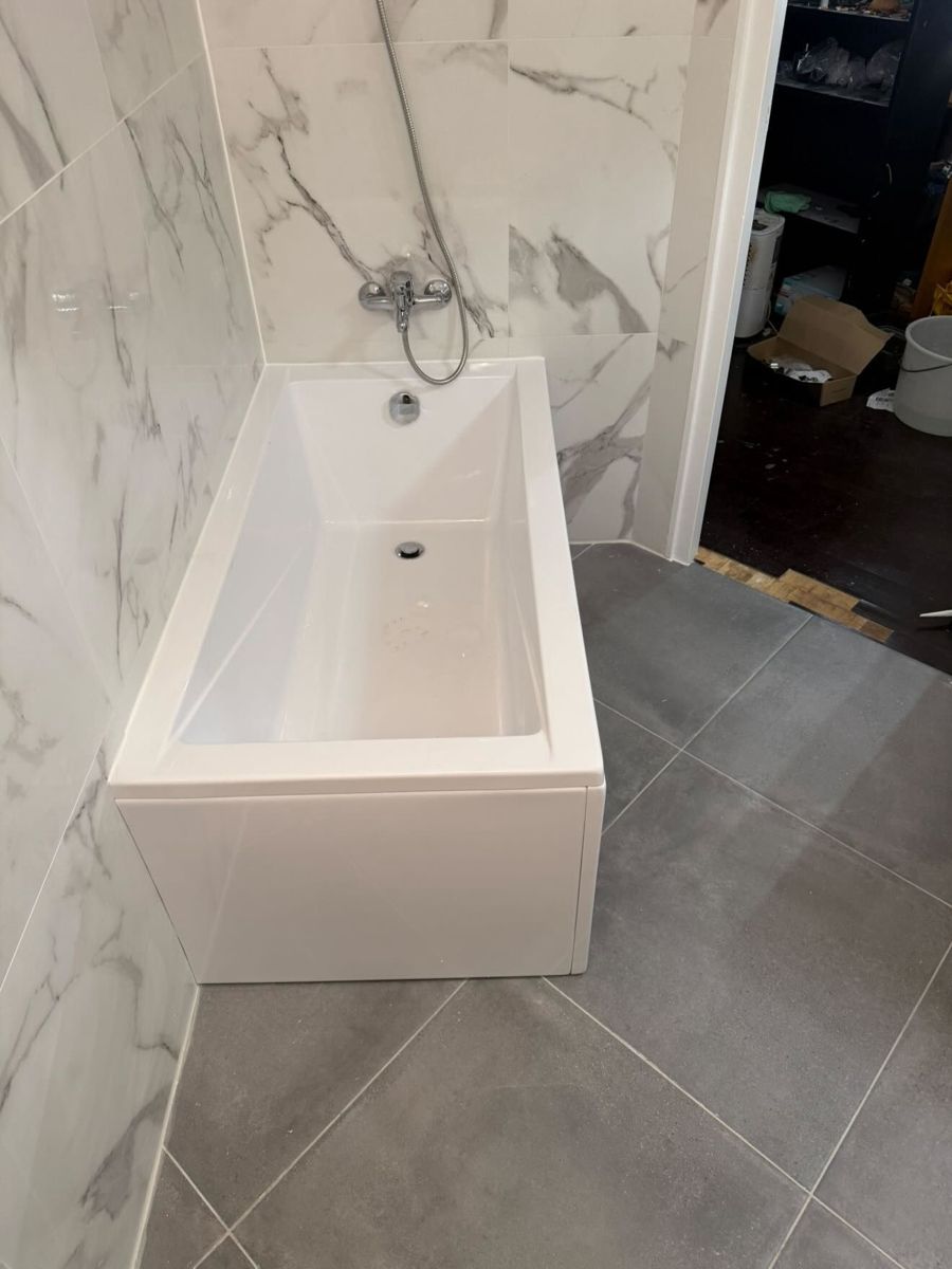 Salle de bain rénovée au Vésinet : baignoire blanche, faïence effet marbre et sol gris anthracite